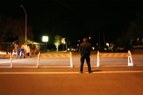 A cop stands in the middle of a closed road