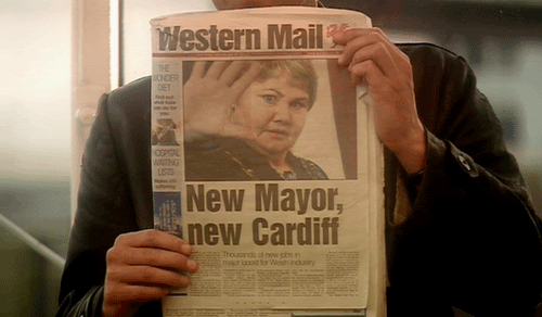 The Doctor holds the newspaper detailing Blaine's placement as Mayor of Cardiff